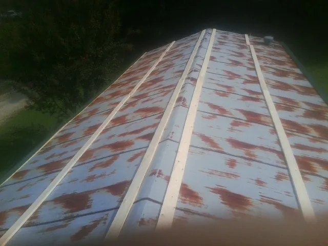 Rusted metal roof panels with new wood purlins before replacement — Storm Damage Roof Repair in Grifton by Roofing Brothers