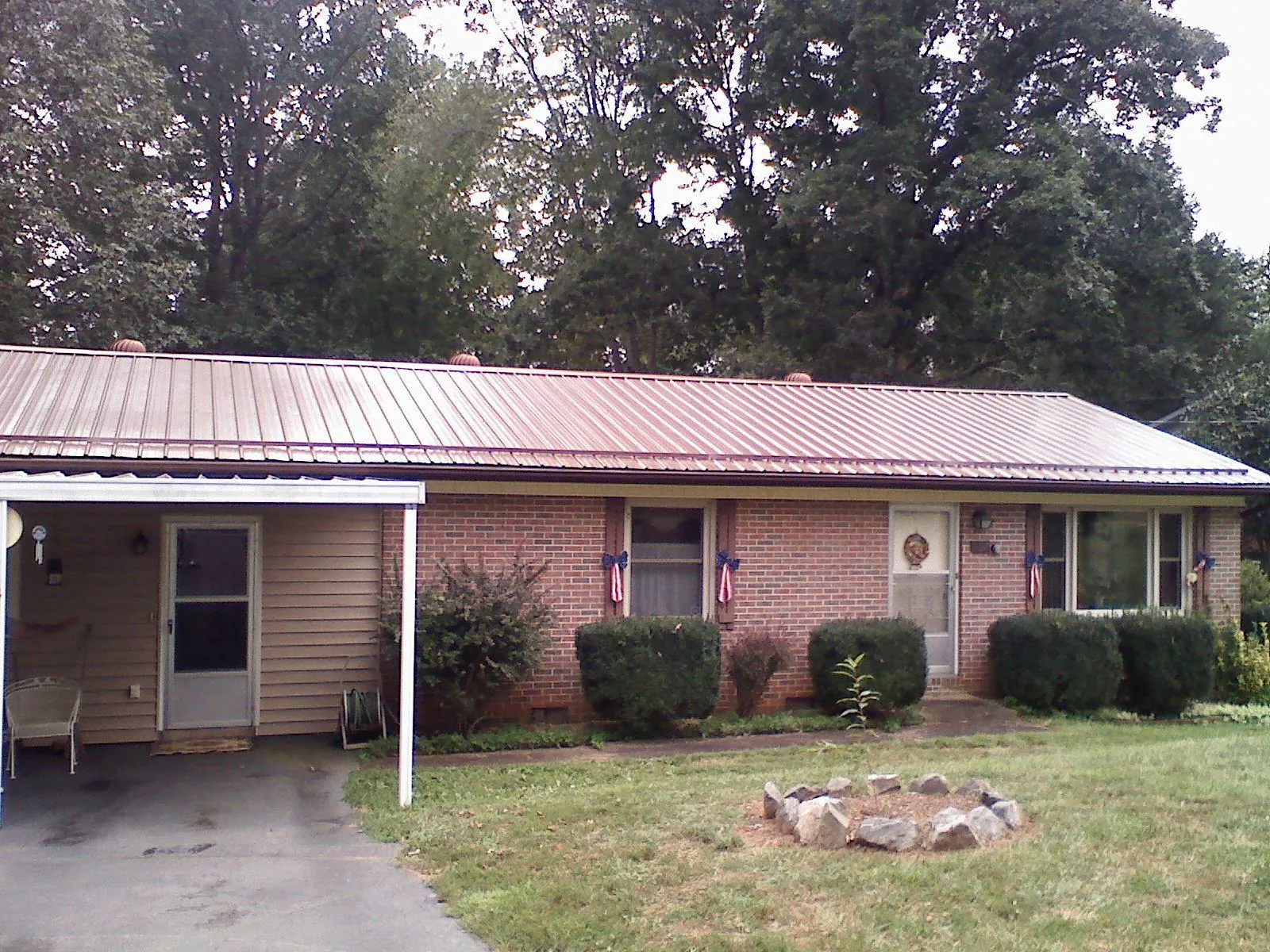 Bronze metal roof and carport on a brick ranch home — Roof Repair work by our crew in Grifton