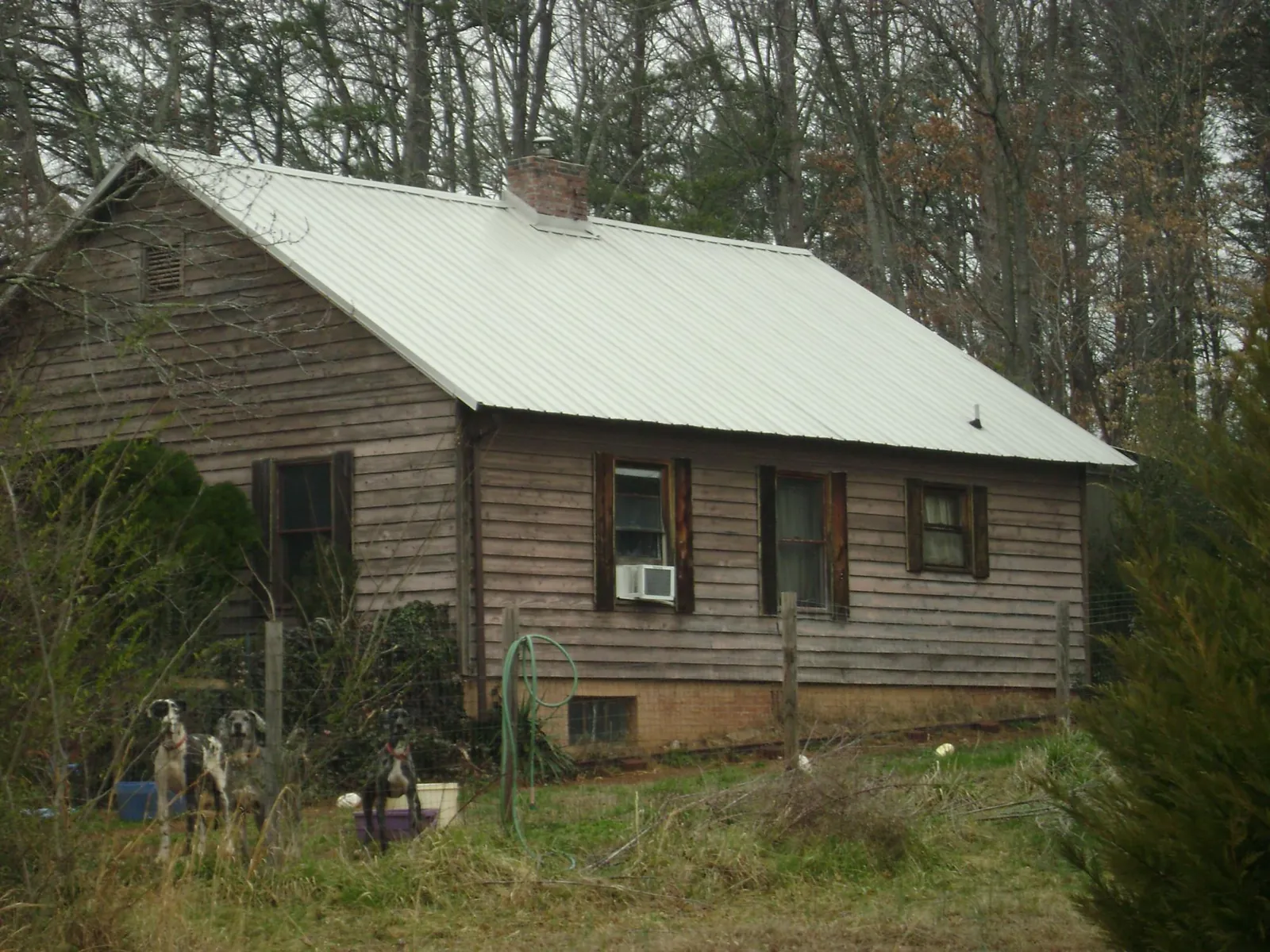 White metal roof on an old wood sided farmhouse, from a Metal Roof Installation job in Grifton